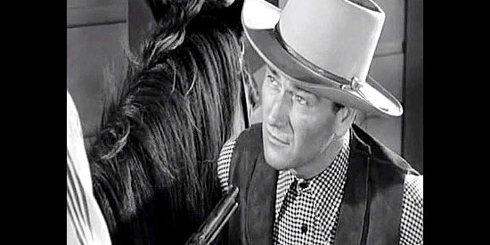 John Wayne as Rocklin, a newcomer to town finding himself under Arly Harolday's gun in Tall in the Saddle (1944)