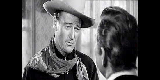John Wayne as Rocklin, meeting Judge Robert Garvey (Ward Bond) in Tall in the Saddle (1944)