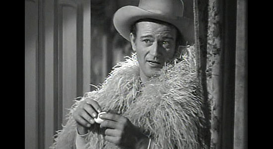 John Wayne as Roy Glennister, finding McNamara in Cherry's room, though he got there first in The Spoilers (1942)