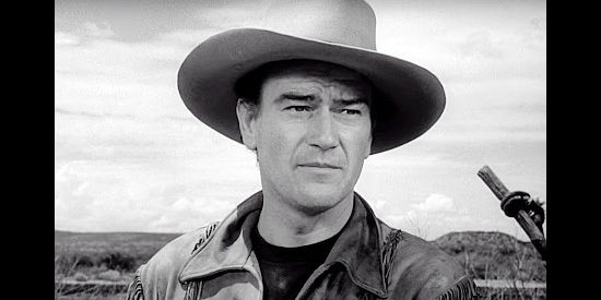John Wayne as Tom Dunson, watching signs that Indians attacked the wagon train in Red River (1948)