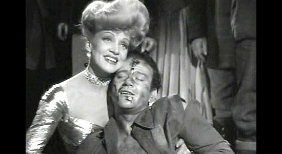 Marlene Dietrich as Cherry Malotte and John Wayne as Roy Glennister, embracing after a wicked fight in The Spoilers (1942)