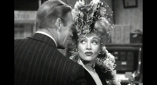 Marlene Dietrich as Cherry Malotte, cool to the advances of Alexander McNamara (Randolph Scott), at least for now, in The Spoilers (1942)