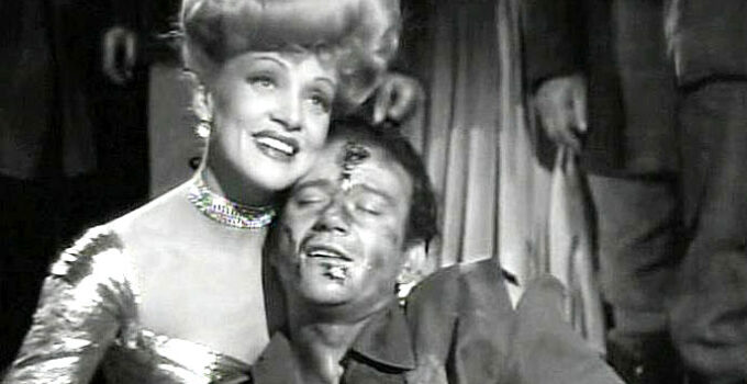 Marlene Dietrich as Cherry Malotte and John Wayne as Roy Glennister, embracing after a wicked fight in The Spoilers (1942)