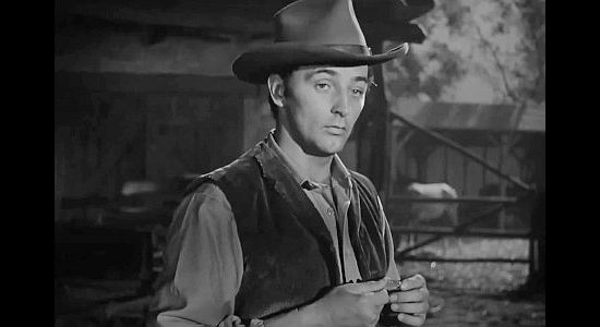 Robert Mitchum as Jeb Rand, holding the coin that helped determine his fate in Pursued (1947)