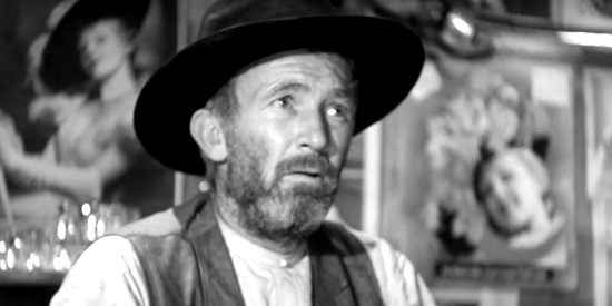 Walter Brennan as Judge Roy Bean, posters of Lilly Langtry plastered all over his barroom wall in The Westerner (1940)