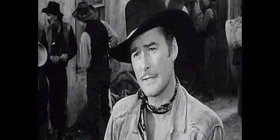 Errol Flynn as Mike McComb, arriving in the silver fields and commandeering Georgia Moore's freight wagons in Silver River (1948)