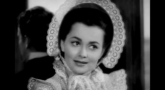 Olivia de Havilland as 'Kit Carson' Holliday, meeting George Custer and Jed Stuart on a train ride to Kansas in Santa Fe Trail (1940)