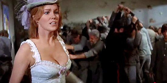 Barbara Rhoades as Miss Jessie Brundidge, a school teacher looking for someone to help her out of her predicament in There Was a Crooked Man (1970)