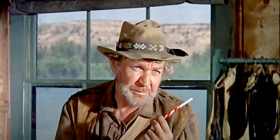 Forrest Tucker as Mountain Phil, making a point with Travis while satisfying his sweet tooth in Barquero (1970)
