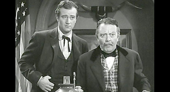 John Wayne as Bob Seton and Raymond Walburn as Judge Buckner, announcing the start of the Civil War in Dark Command (1940)