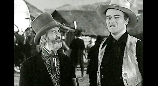 John Wayne as Bob Seton, changing his mind about spending time in Lawrence, Kansas as a confused Doc Grunch (Gabby Hayes) looks on in Dark Command (1940)