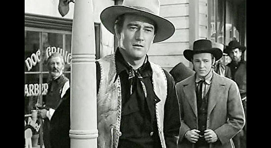 John Wayne as Bob Seton, sensing growing trouble in Lawence, Kansas as Fletch McCloud (Roy Rogers) looks on in Dark Command (1940)