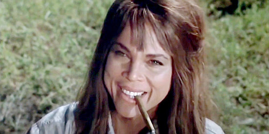 Maria Gomez as Nola, exchanging a knowing glance with Travis in Barquero (1970)