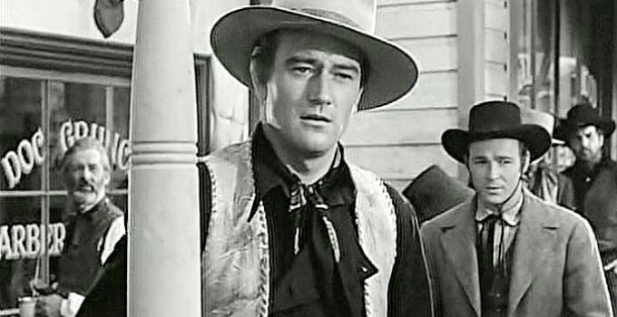 John Wayne as Bob Seton, sensing growing trouble in Lawence, Kansas as Fletch McCloud (Roy Rogers) looks on in Dark Command (1940)