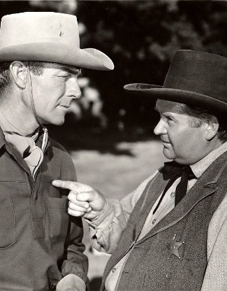 Randolph Scott as Brazos Kane listens to Charles Kemper as Sheriff Kiscaden in Gunfighters (1947)