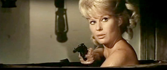 Silvia Solar as Violet pulls a gun on an officer who interrupts bath time in Finger on the Trigger (1965)