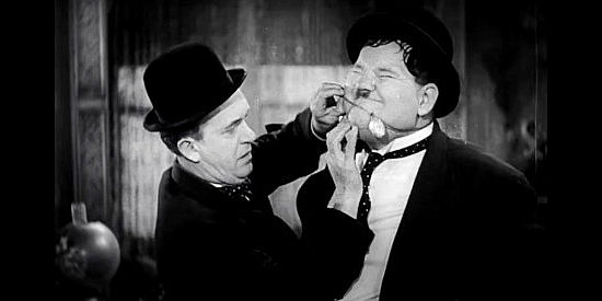 Stan Laurel tries to get a locket from around Oliver Hardy's neck the hard way in Way Out West (1937)
