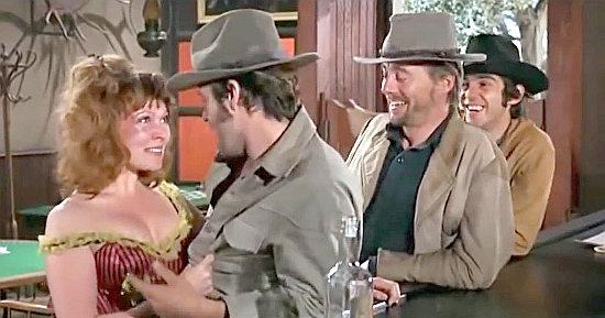 Susan Tyrrell as saloon girl Alma wants to snuggle with Robert F. Lyons as Bobby Jay Jones in Shoot Out. John Davis Chandler as Skeeter and Pepe Serna as Pepe want in on the fun