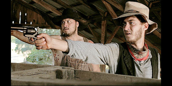 Van White as Killion Benoit and Casey Frey as Patrick 'Tricky' Smith, engaged in a gunfight with Jasper Mudd in The Gunfighter (2015)