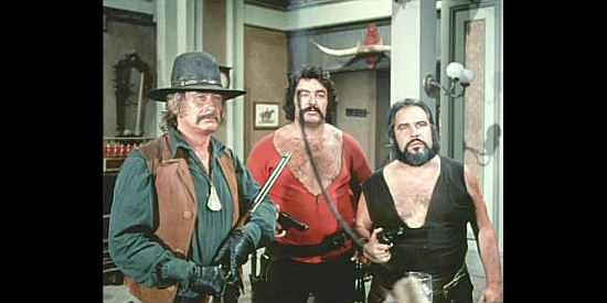 Cray's top henchmen prepare to stand up against Sacramento in spite of a stick of dynamite in And Now They Call Him Sacramento (1972)