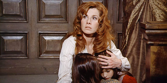 Stefanie Powers as Laurie Gunn, cradling two youngsters as an attack unfolds in The Magnificent Seven Ride! (1972)