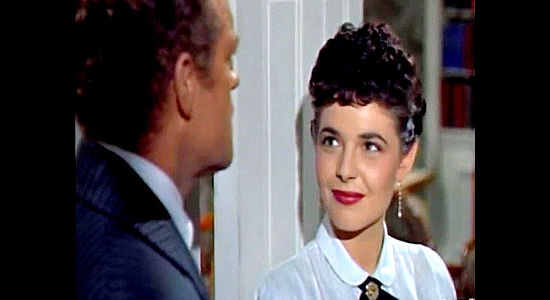 Ann Bancroft as Katy Bishop, looking on admiringly as Neal Benton is thanked for saving a preacher's life in The Raid (1954)