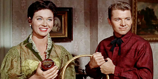 Gia Scala as Tessa Milotte and Audie Murphy as Joe Maybe, accepting a gift basket in Ride a Crooked Trail (1958)