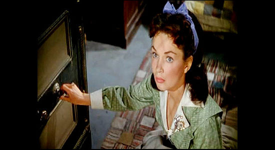 Gloria Henry as Beth Forbes, warily opening the assay office safe for an outlaw in Rancho Notorious (1952)