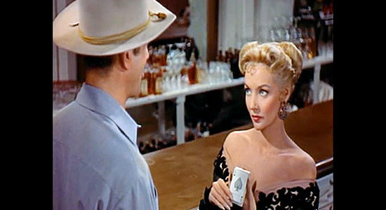 Marie Blanchard as saloon owner Lou Carter, flashing a clue in a murder to Jefferson Harder in Rails Into Laramie (1954)