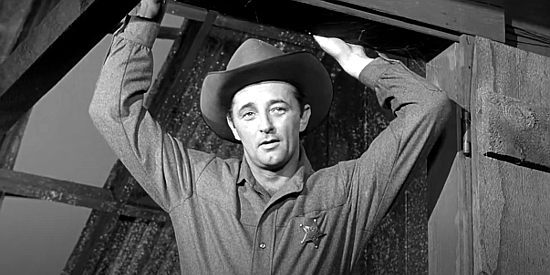 Robert Mitchum as Clint Tollinger, looking for answers in Sheridan City in Man with the Gun (1955)
