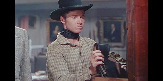 Audie Murphy as Billy the Kid, putting away his guns at the request of rancher Jameson in The Kid from Texas (1950)