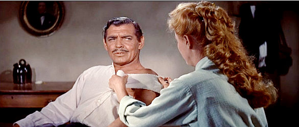 Clark Gable as Dan Kehoe, being patched up by Sabina (Eleanor Parker) in The King and Four Queens (1956)
