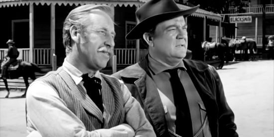 Frank Ferguson as Joe Patterson and Hugh Sanders as Martin Maroon watch one of Patterson's stagecoaches leave town in The Phantom Stagecoach (1957)