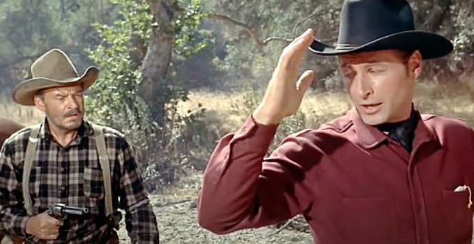 Lex Barker as Jeff Carr, welcomed to the Tomahawk area by the gun of Shep Bascom (Ray Teal) in The Man from Bitter Ridge (1955)