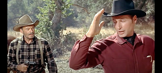 Lex Barker as Jeff Carr, welcomed to the Tomahawk area by the gun of Shep Bascom (Ray Teal) in The Man from Bitter Ridge (1955)
