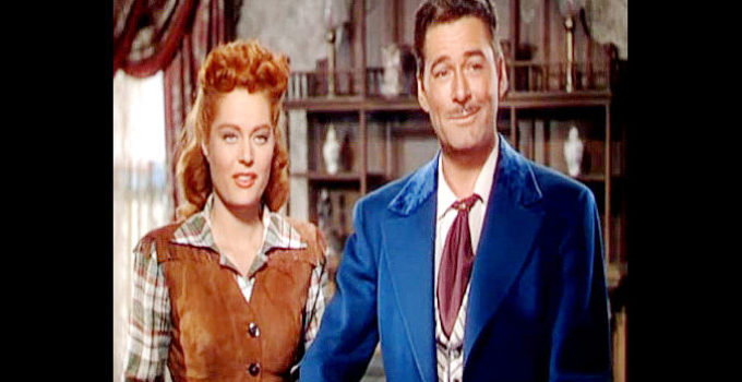 Alexis Smith as Maria Singleton and Errol Flynn as Morgan Lane, caught playing guitar in Montana (1950)