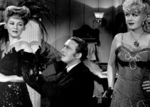 Claire Trevor as Dora Hand commanding the attention of Bat Masterson (Albert Dekker) to the dismay of Daisy Davenport (Marion Martin) in Woman of the Town (1943)