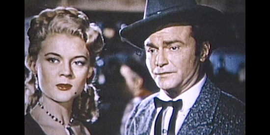 Peggie Castle as Waco Gans, wondering who the new woman is while guilt crosses the face of Jesse James (Donald 'Red' Barry) in Jesse James' Women (1954)