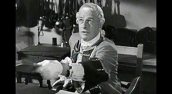 Reginald Denny as British Capt. Edward Brownell, passing Tom Cutler a message that will never reach its destination in The Iroquois Trail (1950)