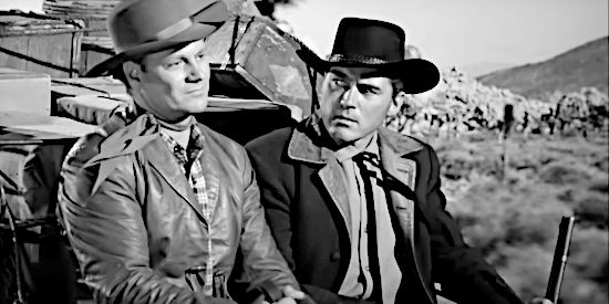 Richard Webb as Tom Bradley and WIlliam Bishop as Glenn Hayden, disagreeing over the value of a loaded shotgun in The Phantom Stagecoach (1957)