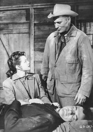 Angie Dickinson as Janice, Robert J. Wilke as Matt Rankin with a wounded James Arness as Rem Anderson in Gun the Man Down (1956)