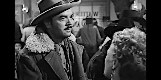 Harry Carter as Rudy Schaeffer, spotting a wanted poster for prison escapee Jim Canfield in The Secret of Convict Lake (1951)