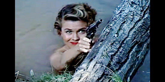 Joann Dru as Lilly, about to take a shot at a peeping tom in Southwest Passage (1954)