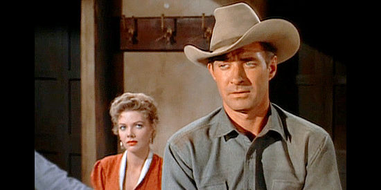 Jock Mahoney as Joe Dakota, asking questions about his Indian friend while Myrna Weaver (Barbara Lawrence) looks on in Joe Dakota (1957)