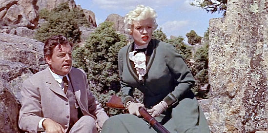 Kenneth Moore as Jonathan Tibbs and Jayne Mansfield as Kate, taking cover as trouble converges in The Sheriff of Fractured Jaw (1958)