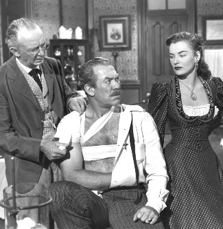 Walter Brennan as Dr. Jonathan Mark, Ward Bond as Sheriff Jim Caradoc and Ella Raines as Nan Moran in Singing Guns (1950)