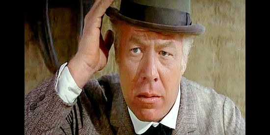 George Kennedy as Hoke Birdsill, trying to hold onto a derby full of dollars in Dirty Dingus Magee (1970)