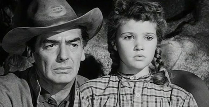 Victor Mature as Ben Lassiter with young daughter Abbey (Reba Waters), pinned down by Apache in Escort West (1959)