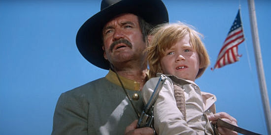 Rod Taylor as Frank Brand, holding Keven Kilpatrick (Sean Marshall) hostage in The Deadly Trackers (1973)