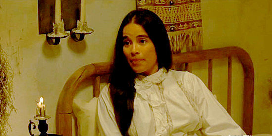 Alma Martinez as Juanita, offering to hide Karl Westover in her bed in Barbarosa (1982)